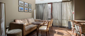 A patterned sofa and two sets of tables and chairs in the dining room