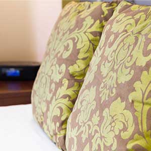 A close up of two brown pillows with green floral patterns on them