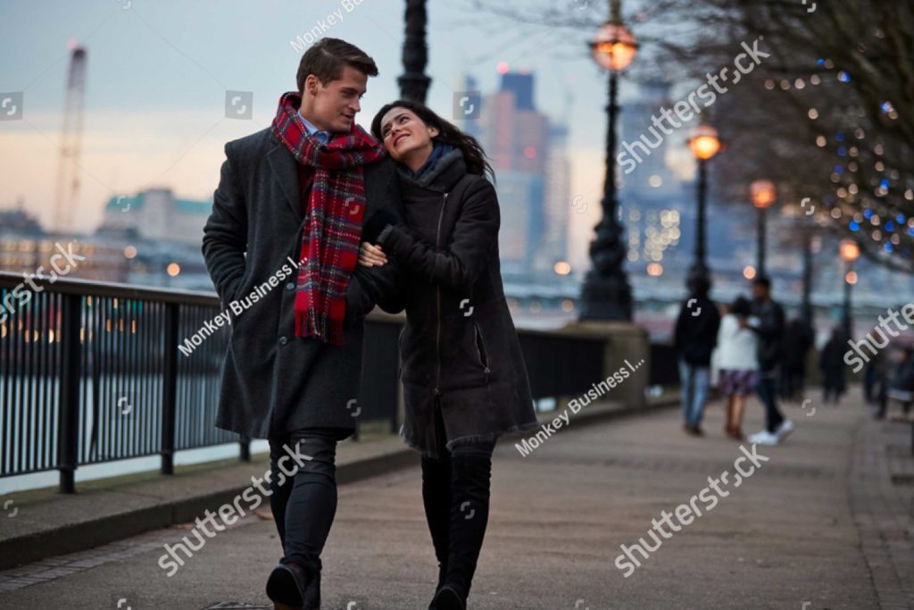 A woman gazes into the eyes of a man as they walk on the Southbank